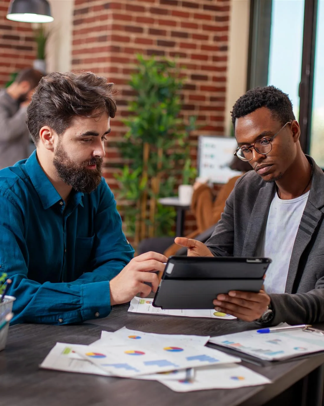 Two professionals reviewing billing figures together on a tablet