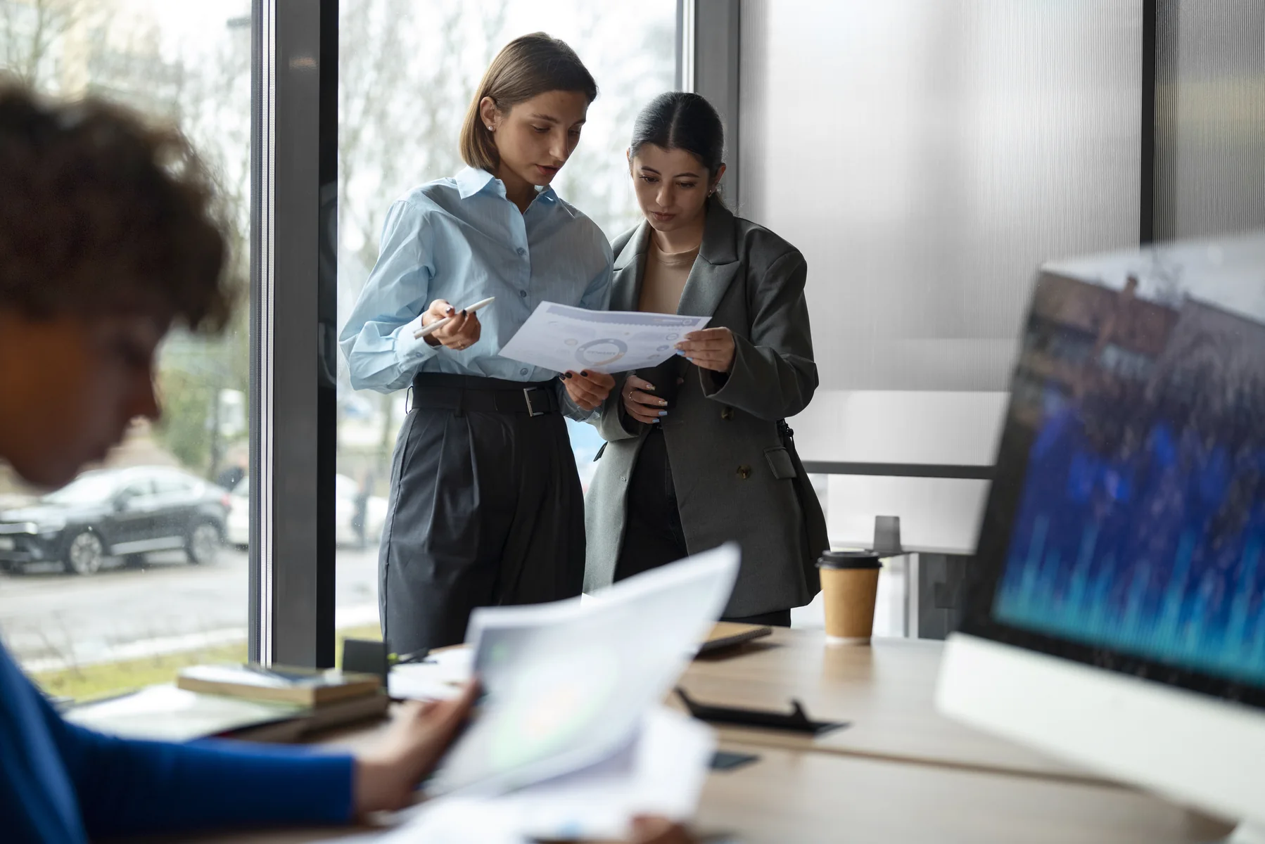 Two colleagues reviewing a billing document together in a bright office